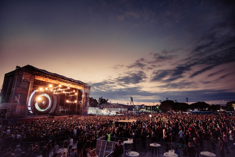 Velika publika ispred osvijetljene pozornice Sea Star festivala u sumrak